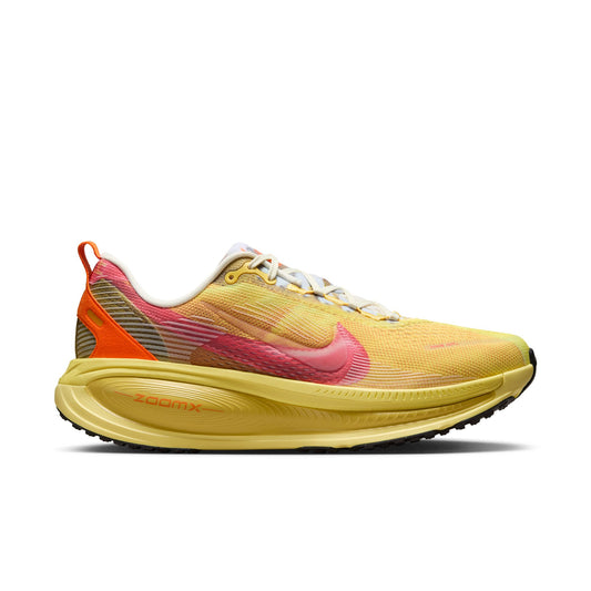 Yellow running shoe with pink accents on a white background