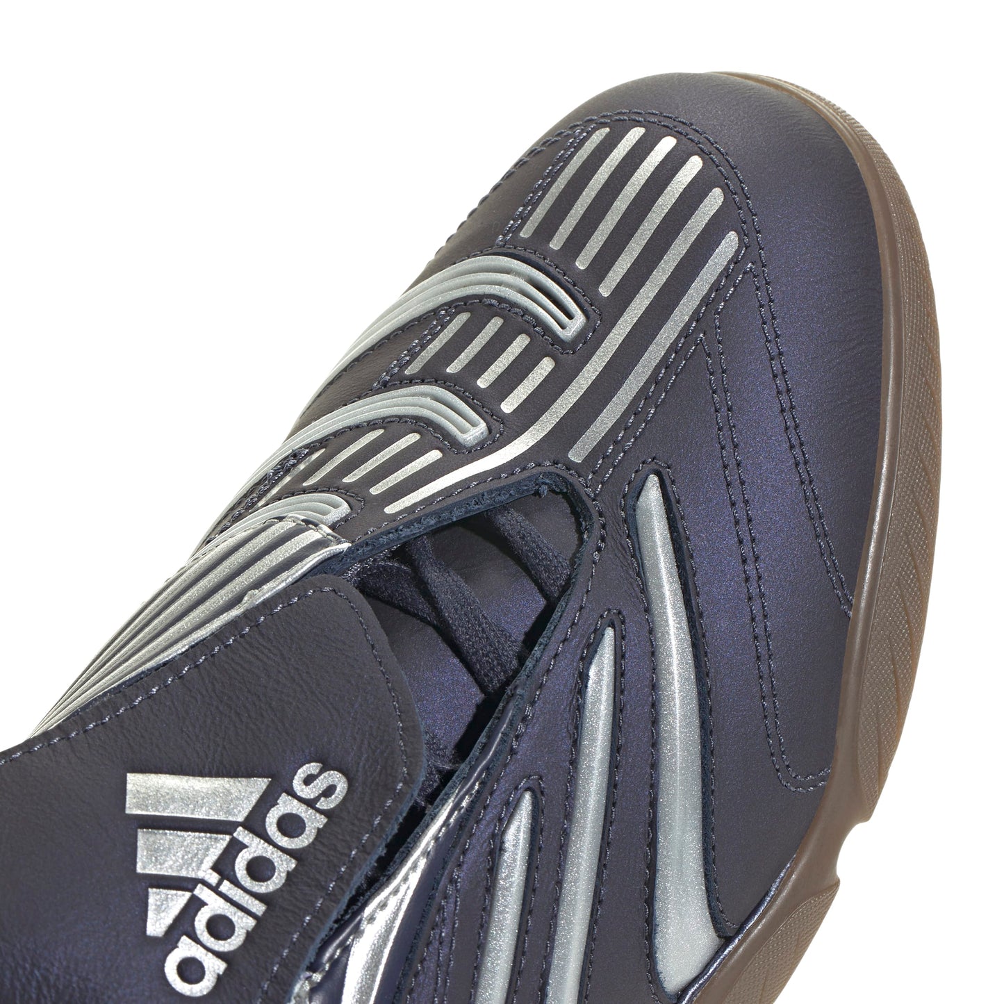 Navy blue athletic shoe with silver accents and Adidas logo on a white background