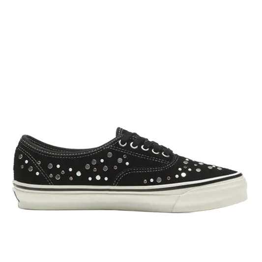 Black sneaker with silver studs on a white background