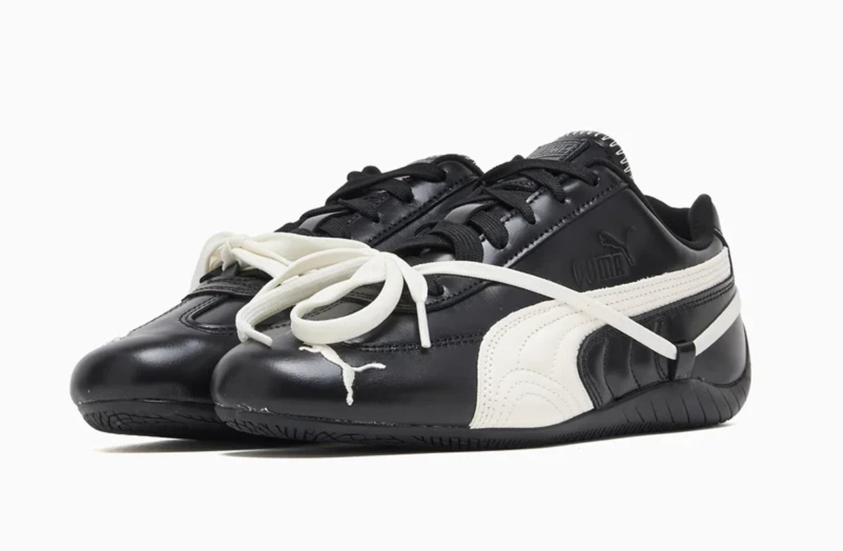 Black and white Puma sneakers with a visible brand logo on a white background