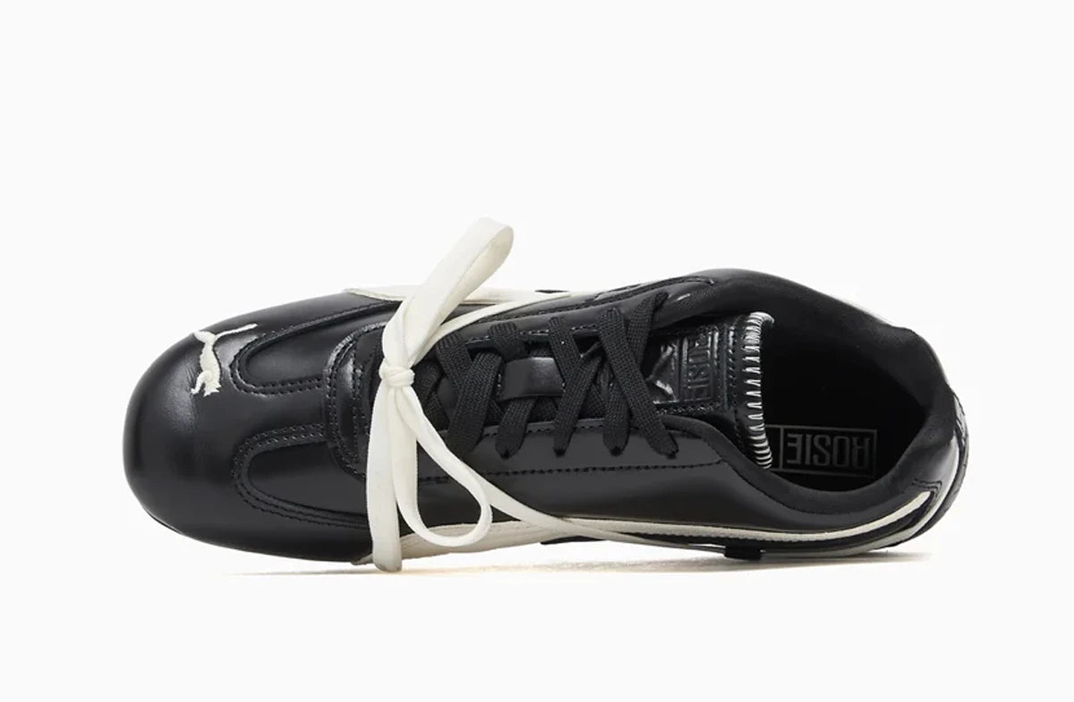 Top view of Puma Black sneaker with white laces on a white background