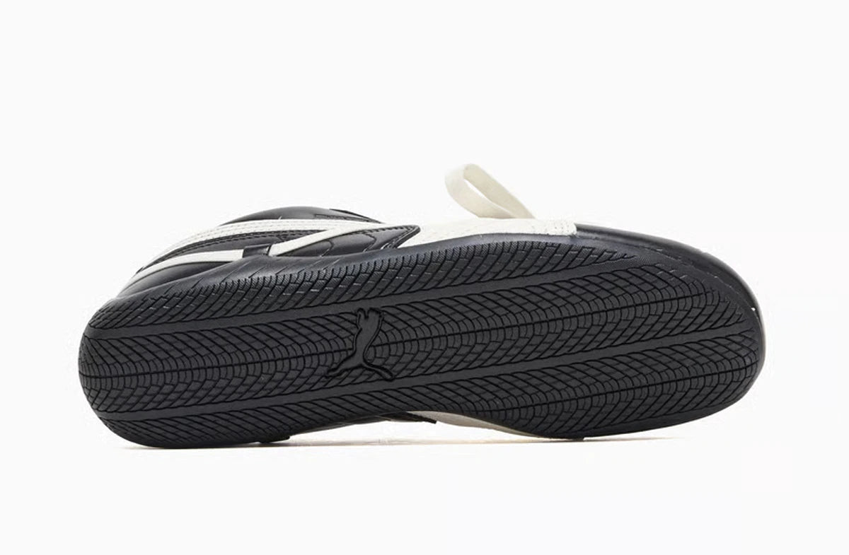 Black and white sneaker with tread pattern on a white background