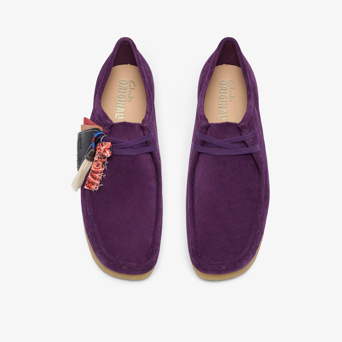 Clarks Wallabee top view of pair in Damson Suede, purple laces, bandana and leather charm tags, crepe soles