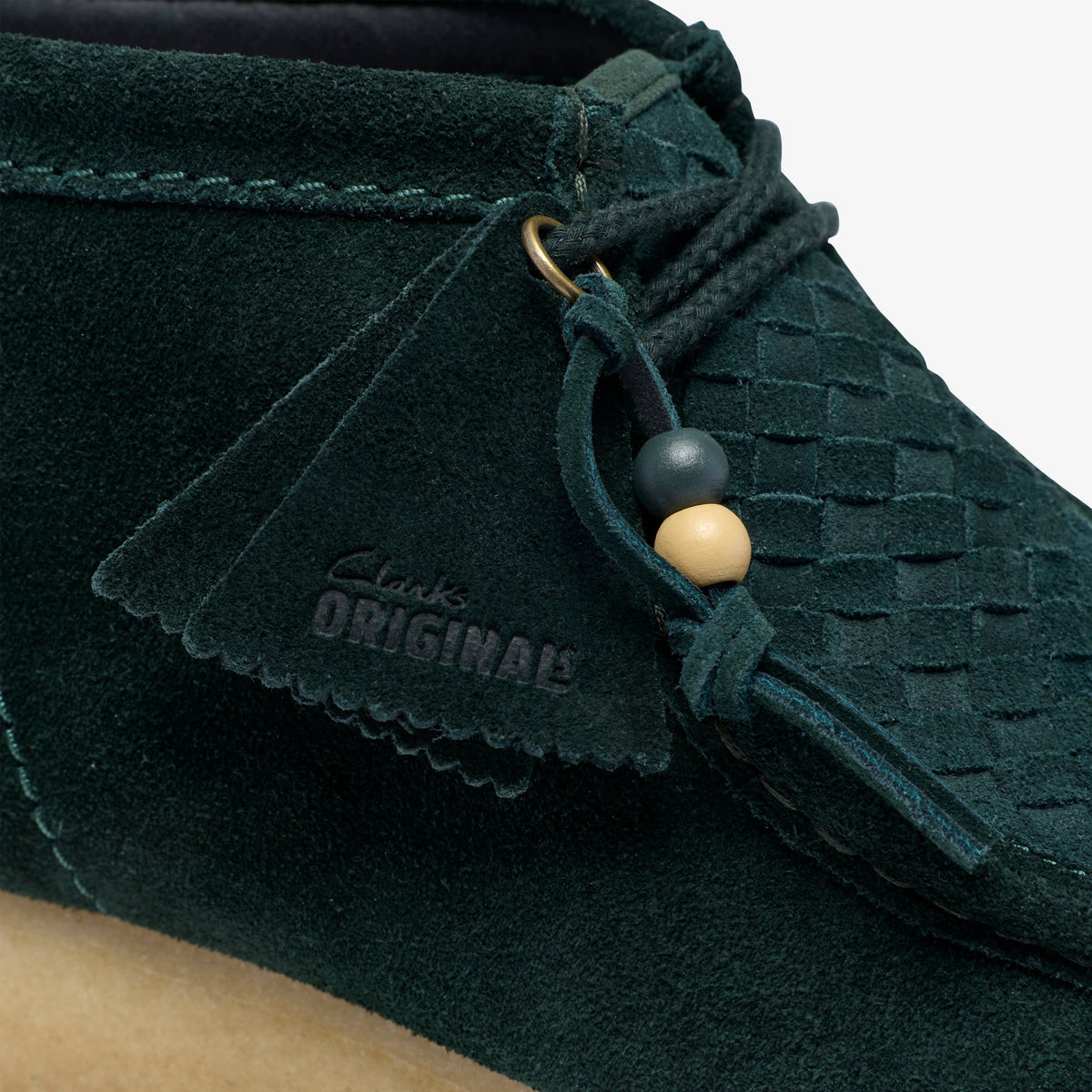 Clarks Wallabee Boot close-up in Forest Green Weave, woven suede toe, embossed Clarks Originals tag and lace beads