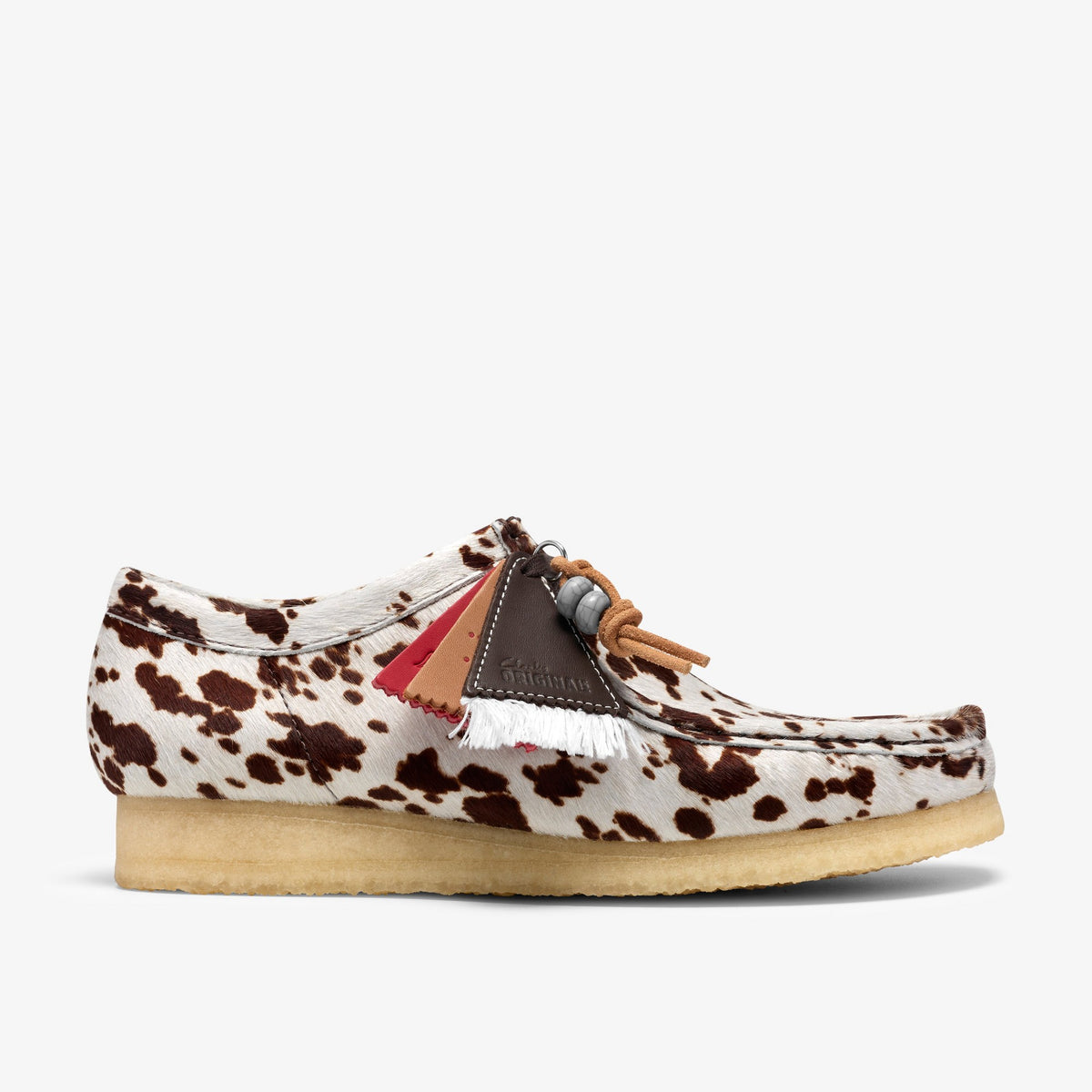 Clarks Wallabee side view in Brown Cow Print hair-on upper with layered fringe tags, beaded laces, crepe sole