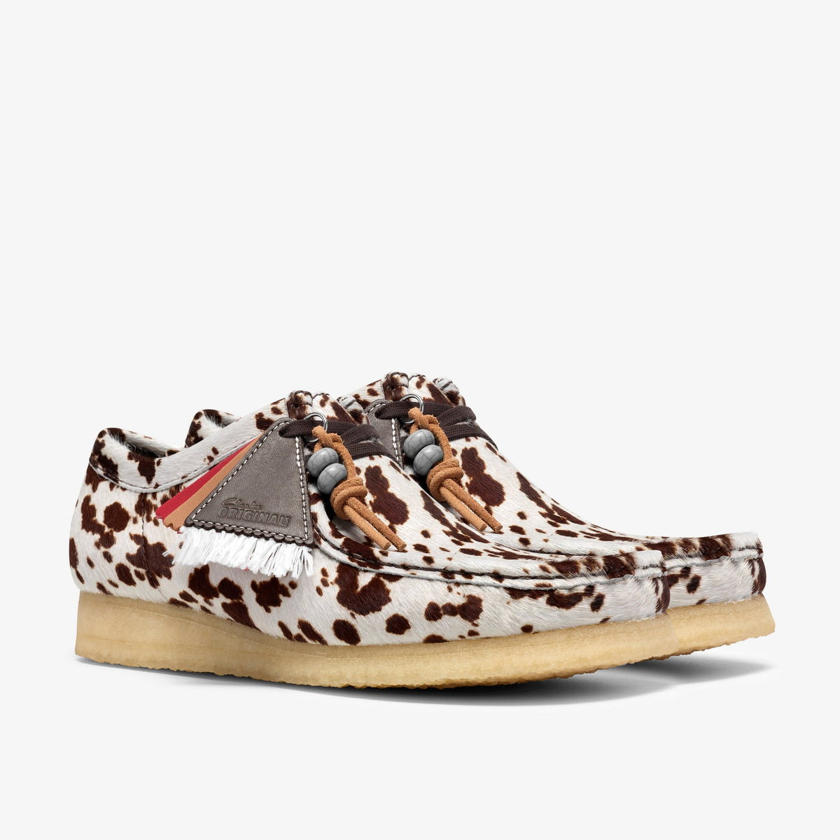 Clarks Wallabee pair, front angle, Brown Cow Print hair upper, red stripes, white fringe, beaded laces, crepe sole