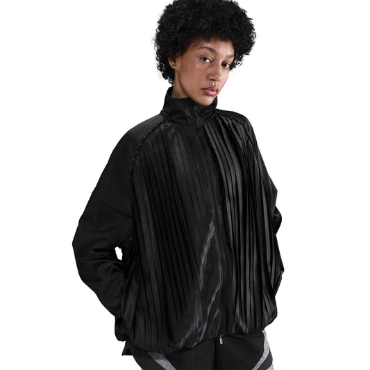 Person wearing a black pleated jacket on a white background