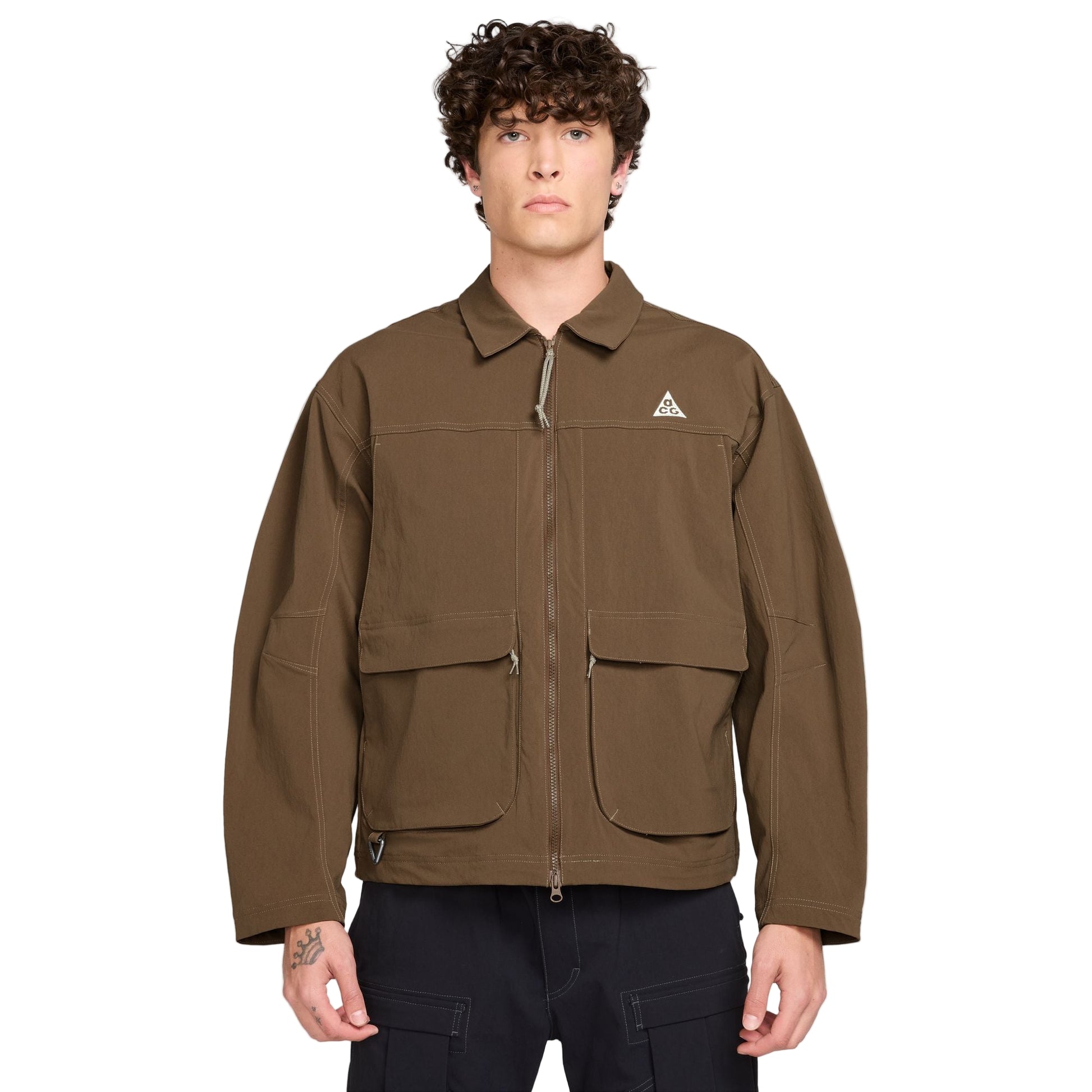 Man wearing a brown jacket with a Nike ACG logo on a white background