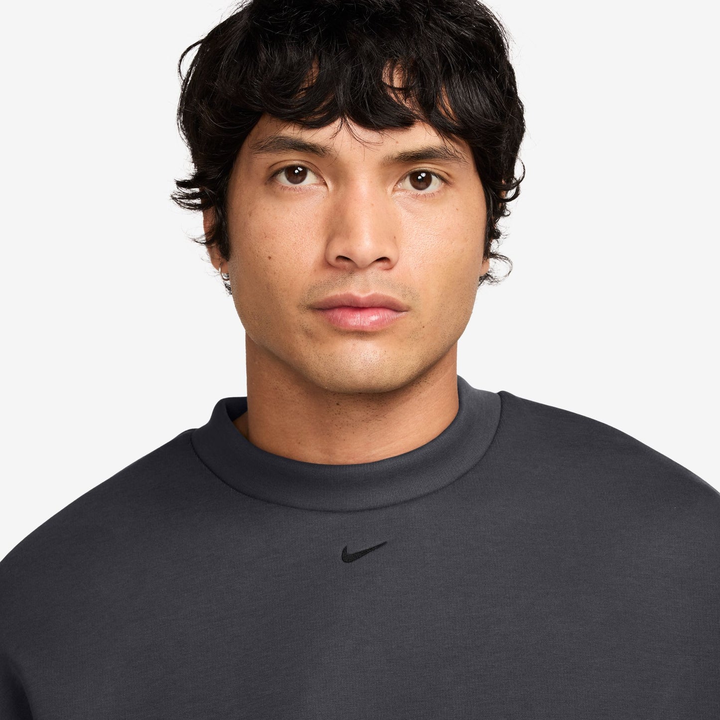Man wearing a dark gray Nike sweatshirt on a white background