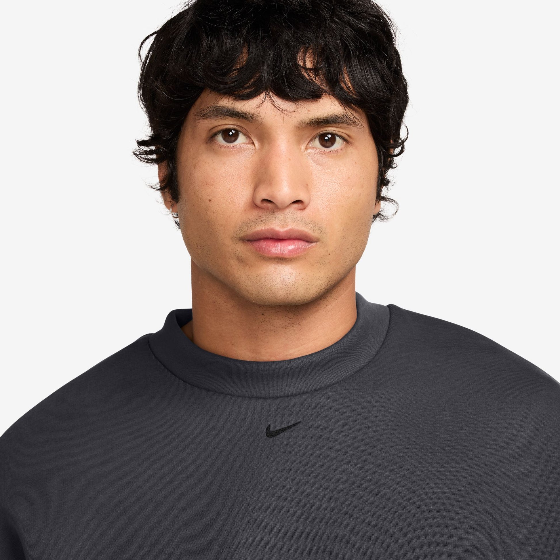 Man wearing a dark gray Nike sweatshirt on a white background