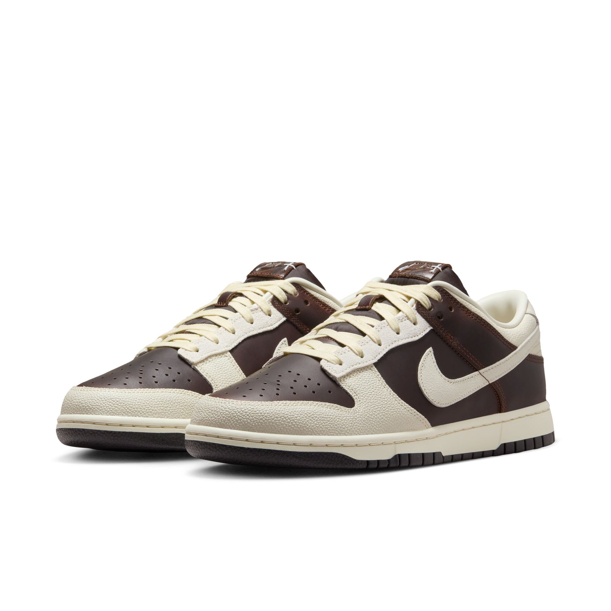 Pair of brown and beige Nike Dunk Low with a Nike logo on a white background