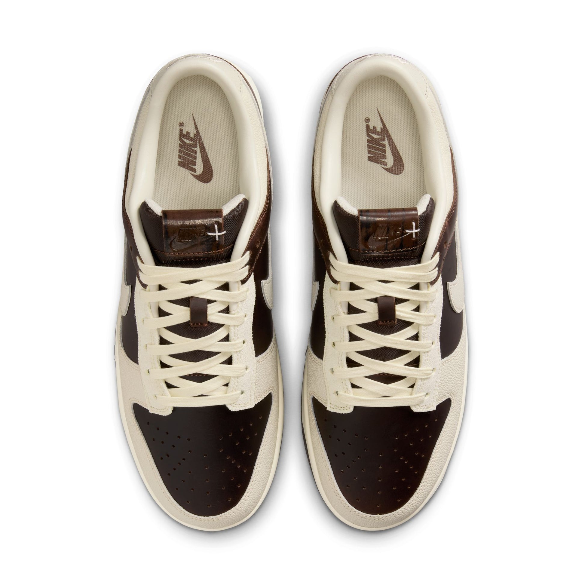 Pair of brown and beige sneakers with a Nike logo on a white background