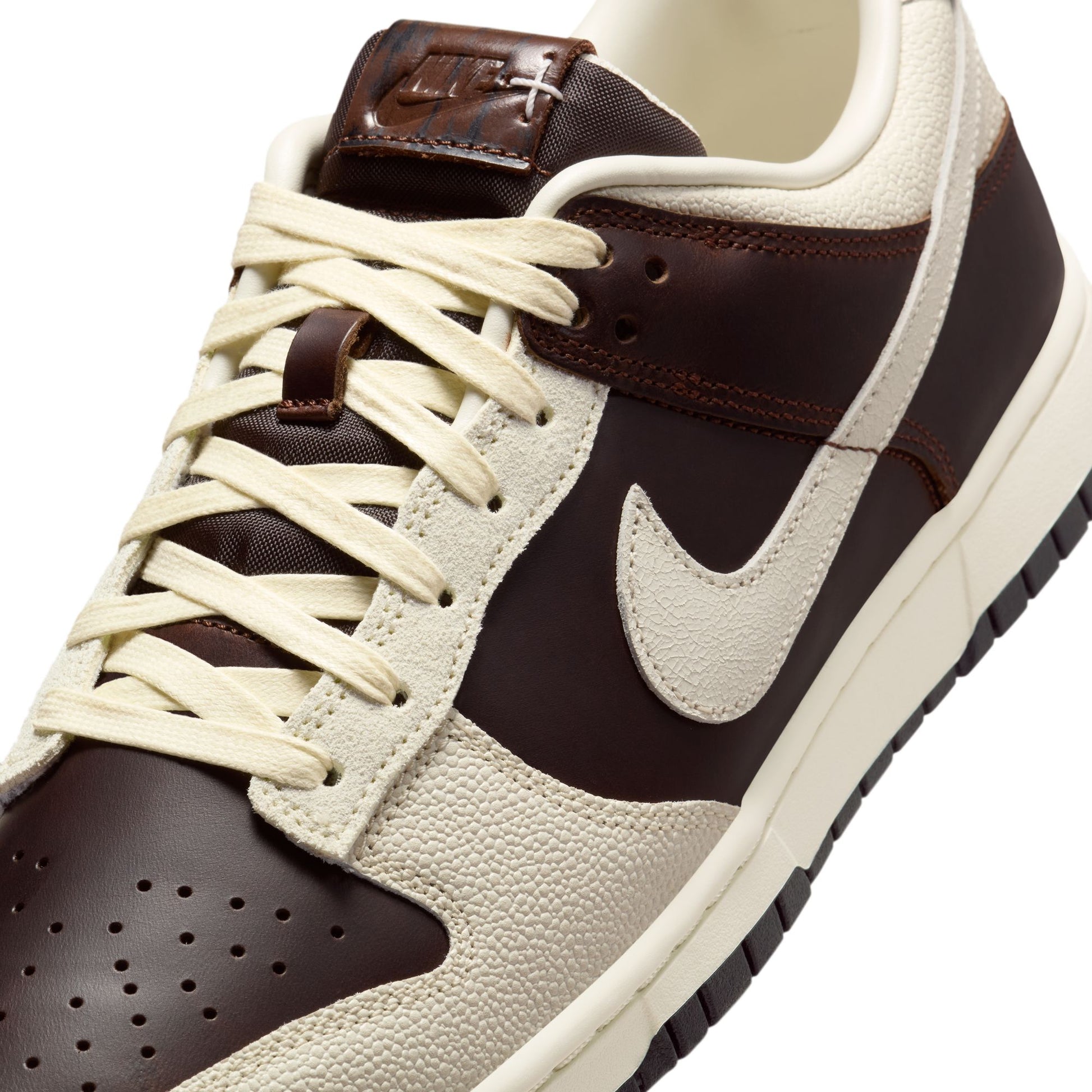 Brown and beige Nike Dunk with a prominent Nike logo on a white background