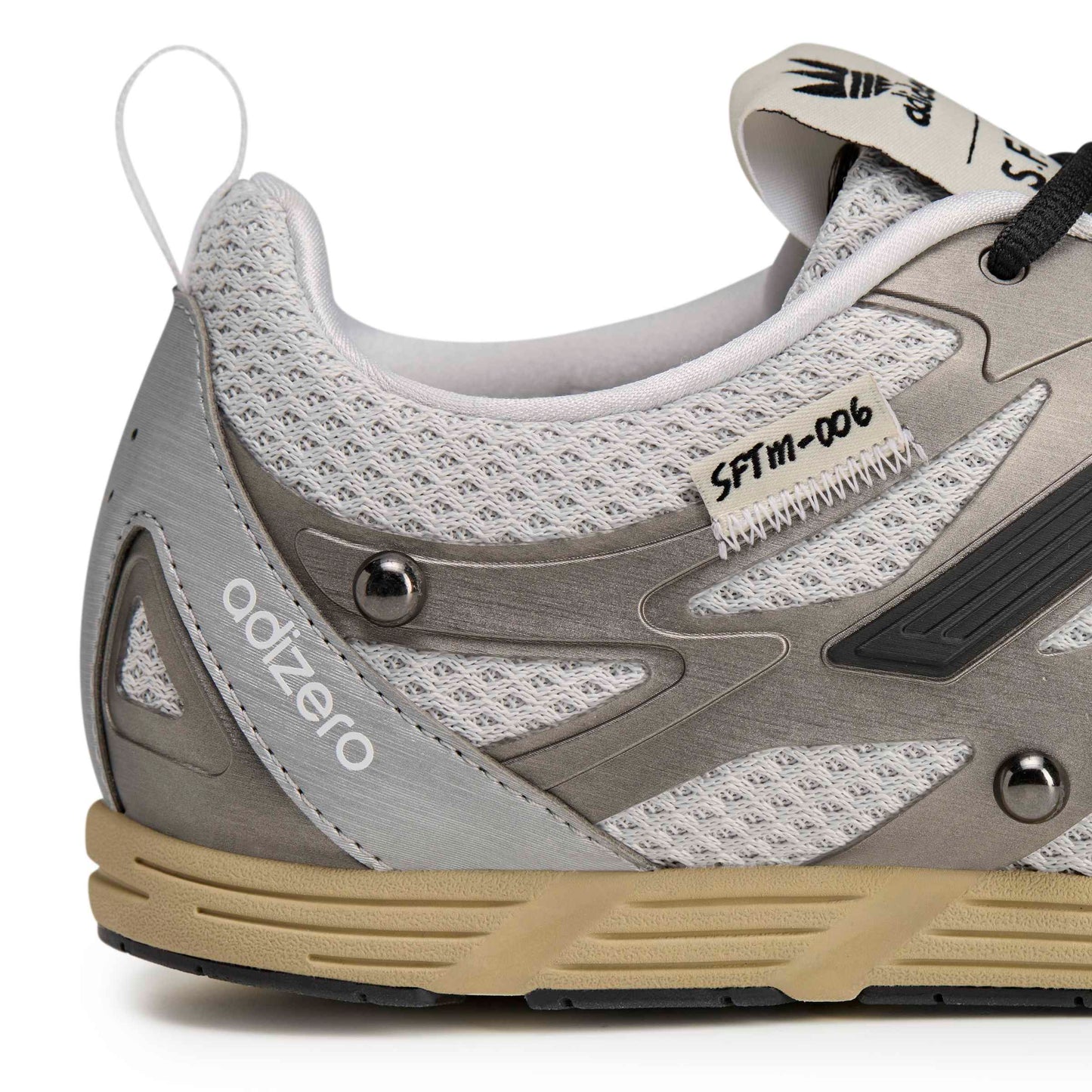 Gray and beige athletic shoe with 'adizero' branding on a white background