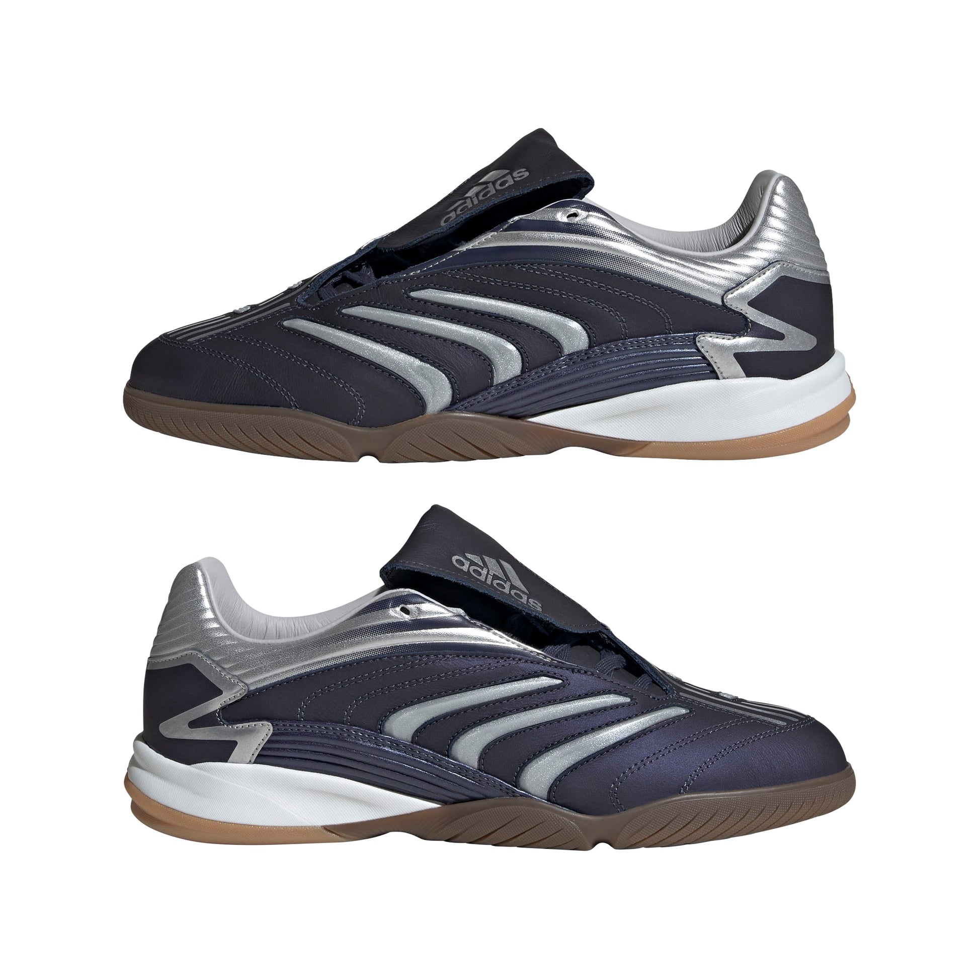 Pair of black and silver athletic shoes with brown soles on a white background