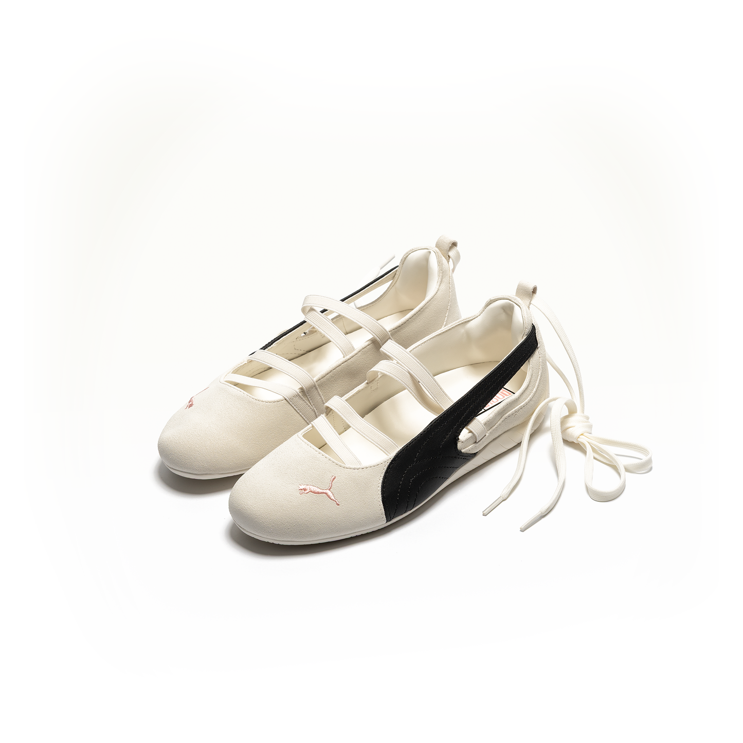 Natural white Puma Ballerina inspired shoes with black accents on a white background