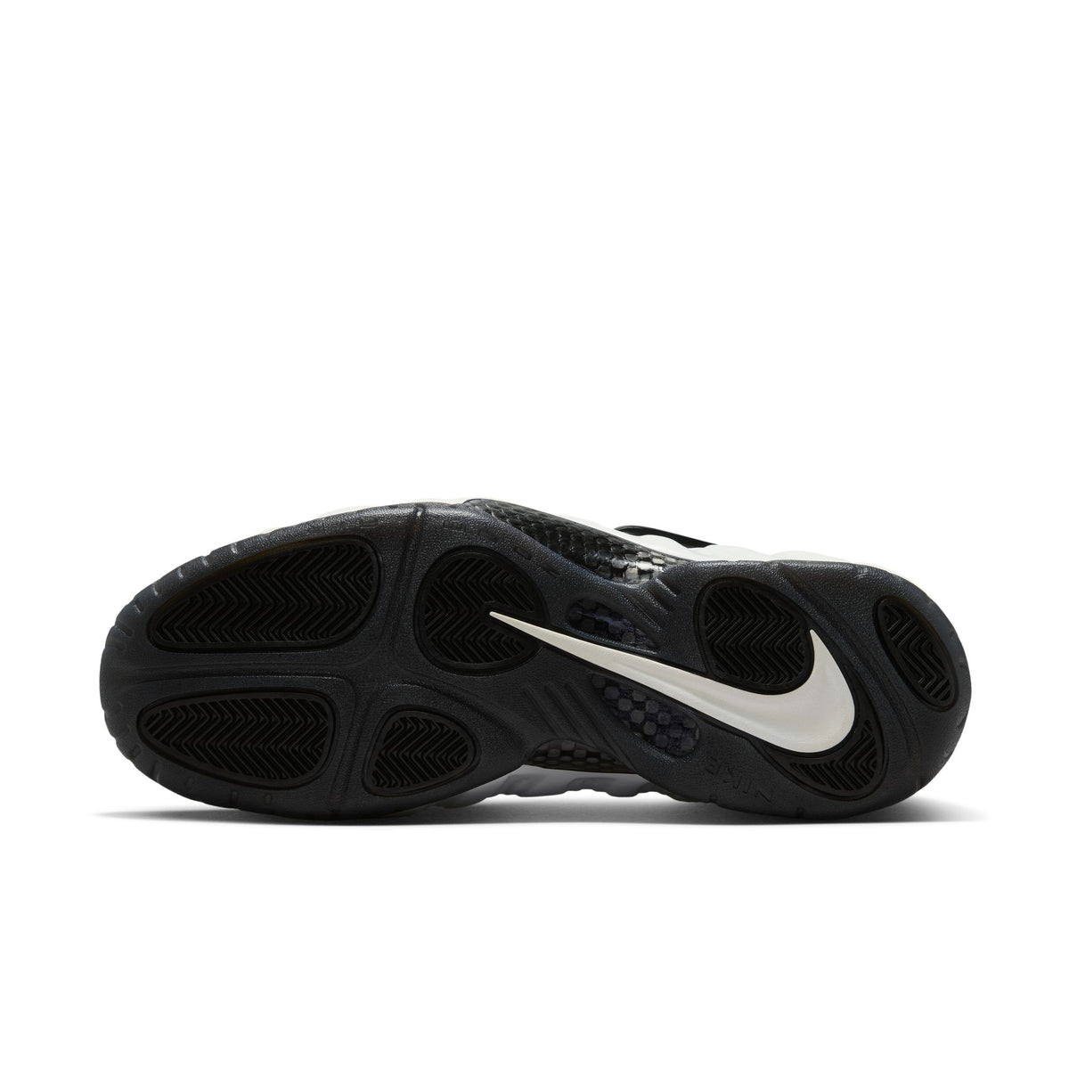 Nike Air Foamposite Pro sole view: black rubber outsole with herringbone traction pods and a Summit White Swoosh
