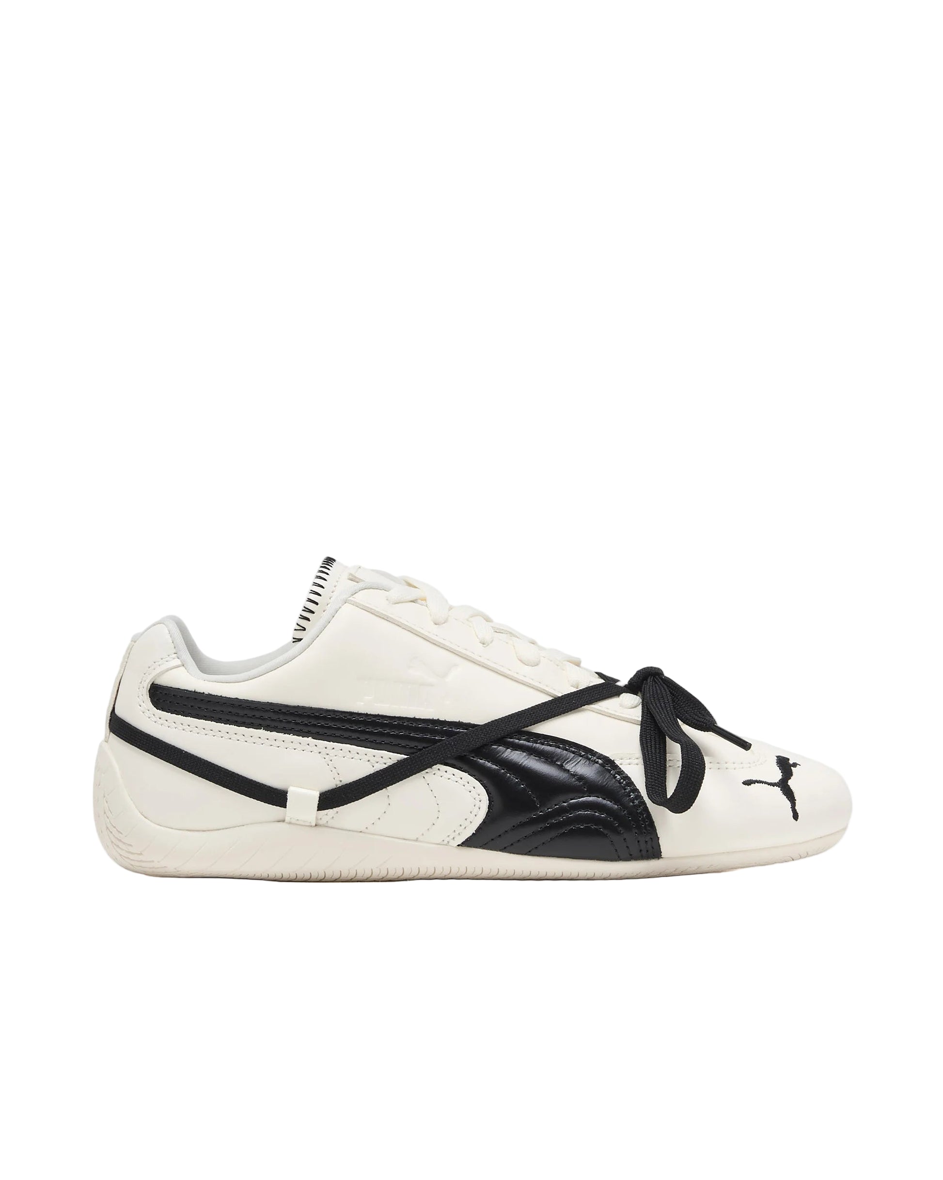 White and black Puma sneaker with a distinctive lacing system on a white background